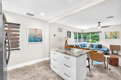 a kitchen and living room with a couch and a table at The Frolics -Stunning Wilton Manors Pool Home in Fort Lauderdale