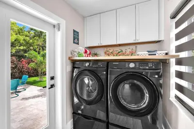 a kitchen with a washer and dryer in a room at The Frolics -Stunning Wilton Manors Pool Home in Fort Lauderdale