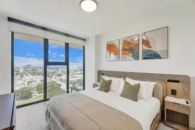 a bedroom with a large bed and a large window at 72 Park by Nomada Residences in Miami Beach