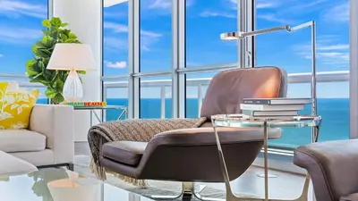 a living room with a chair and a glass table at The Setai Miami Private Luxury Residences in Miami Beach