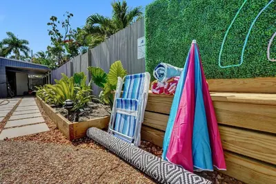 a chair and an umbrella next to a fence at Heated Saltwater Pool Family & Pet-Friendly Oasis in Fort Lauderdale