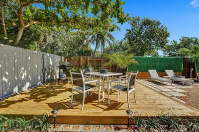 a patio with a table and chairs and a fence at Heated Saltwater Pool Family & Pet-Friendly Oasis in Fort Lauderdale