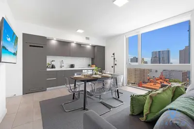 a living room with a table and a kitchen with a view at Beautiful 2BR Apartment with gym and Pool in Miami