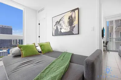 a living room with a couch with green pillows at Beautiful 2BR Apartment with gym and Pool in Miami