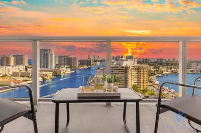 a balcony with a table and a view of a river at Stylish -2BR Apartment -Balcony & Pool in Hallandale Beach