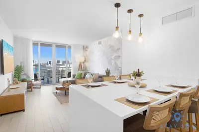 a kitchen and living room with a table and chairs at Stylish -2BR Apartment -Balcony & Pool in Hallandale Beach