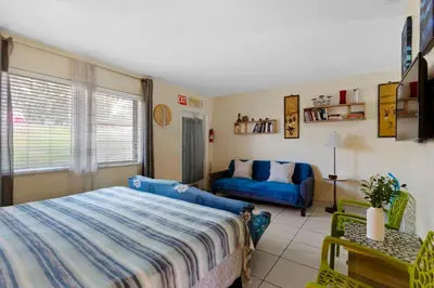 a bedroom with a blue bed and a couch at 1BR Studio Parking, BBQ, Garden In Hollywood in Hollywood