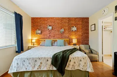 a bedroom with a bed and a brick wall at Pet Friendly Stylish Studio in Hollywood in Hollywood