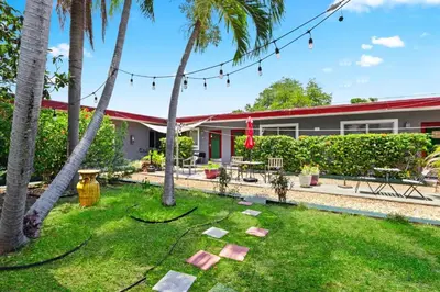 a garden with palm trees and a building at Modern 1BR Studio in Hollywood | Free Parking in Hollywood
