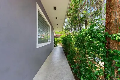 a walkway next to a building with a tree at Relaxing 1BR w/ BBQ, Patio & Convenient Access in Hollywood