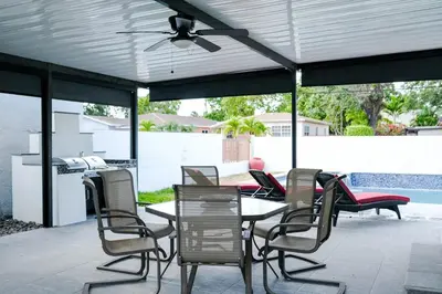 a patio with chairs and tables and a ceiling fan at Miami Freedom Park Oasis by H&S in Miami