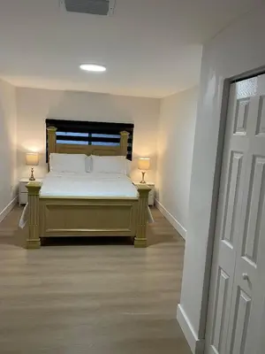 a bedroom with a bed and two lamps on two tables at Miami Freedom Park Oasis by H&S in Miami