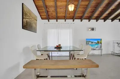 a dining room with a glass table and chairs at Central Stunning Villa with Heated Pool Cabana in Hollywood Ridge Farms