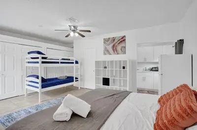 a white bedroom with a bed and a ceiling fan at Central Stunning Villa with Heated Pool Cabana in Hollywood Ridge Farms