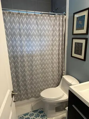 a bathroom with a toilet and a shower curtain at Charming two Bedroom in the Gables For Rent in Miami