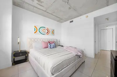 a white bedroom with a large bed with pink pillows at Midblock Midtown Miami 1B W Spa Pool Gym in Miami
