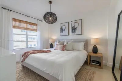 a bedroom with a large white bed and a window at Contemporary chic, next to the beach - 1 Bedroom in Miami Beach