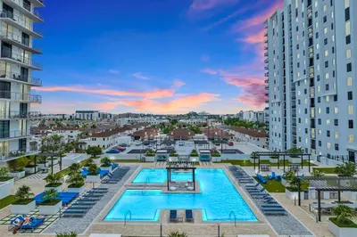 an overhead view of a pool with chairs and buildings at Stylish Studio with Pool View at the Heart of Downtown Doral in Miami