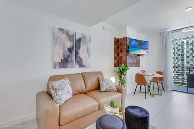 a living room with a couch and a table at Stylish Studio with Pool View at the Heart of Downtown Doral in Miami