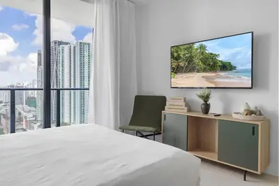 a bedroom with a bed and a desk with a television at Downtown Miami 2BR-2BA Panoramic City Views in Miami