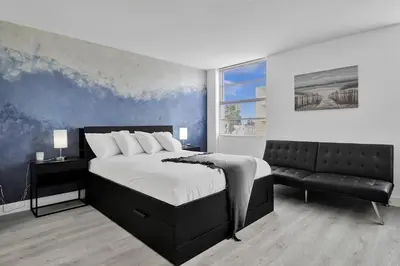 a bedroom with a large bed and a couch at Ocean Dr 1BR • Miami Beach Getaway in Miami Beach