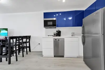 a kitchen with a refrigerator and a table with chairs at Ocean Dr 1BR • Miami Beach Getaway in Miami Beach