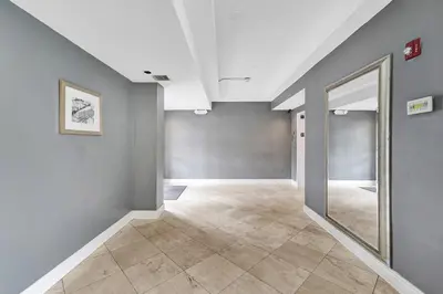 an empty hallway with a large mirror and gray walls at Ocean Dr 1BR • Miami Beach Getaway in Miami Beach
