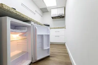 a kitchen with a white refrigerator with its door open at Coastal 2BR Escape | Walk to Beach & 2 Queen Beds in Miami Beach