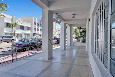 a balcony of a building with a parking lot at Coastal 2BR Escape | Walk to Beach & 2 Queen Beds in Miami Beach