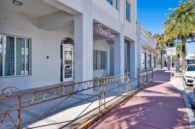 a building with a sign on the side of it at Coastal 2BR Escape | Walk to Beach & 2 Queen Beds in Miami Beach