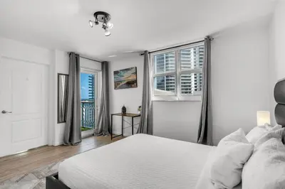 a white bedroom with a bed and two windows at Enjoy Brickell Living 2 BR Retreat With Free Parking in Miami