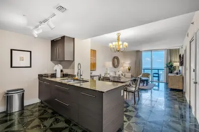 a kitchen with a large island and a living room at Icon Brickell Gem 2-BR Oasis with Amazing Views in Miami