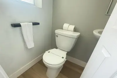 a bathroom with a white toilet and a sink at Dania Beach 1BR | Steps to Ocean + Parking in Dania Beach