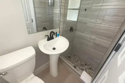 a bathroom with a shower and a sink and a toilet at Dania Beach 1BR | Steps to Ocean + Parking in Dania Beach