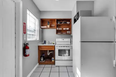 a kitchen with a white refrigerator and a stove at Triplex with 3 Bedrooms, 6 Min/Beach+Free Parking in Dania Beach