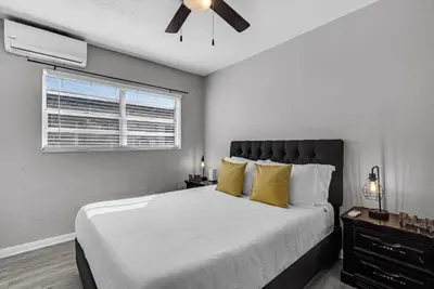a bedroom with a bed with yellow pillows and a ceiling fan at Triplex with 3 Bedrooms, 6 Min/Beach+Free Parking in Dania Beach