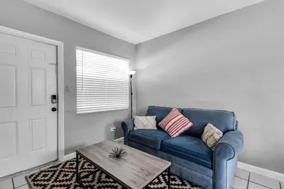 a living room with a blue couch and a coffee table at Cozy 1BR Retreat | 6-Min to Beach + Free Parking in Dania Beach