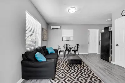 a living room with a black couch and a table at Chic 1BR Getaway Near FLL Airport + 6 MN to Ocean in Dania Beach
