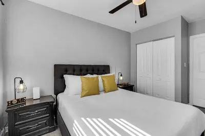 a bedroom with a bed with yellow pillows and a ceiling fan at Chic 1BR Getaway Near FLL Airport + 6 MN to Ocean in Dania Beach