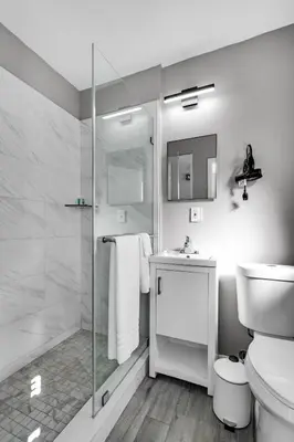 a bathroom with a shower and a toilet and a sink at Chic 1BR Getaway Near FLL Airport + 6 MN to Ocean in Dania Beach