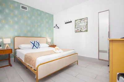 a bedroom with a bed with a blue wall at Boutique Apartments SoBe in Miami Beach