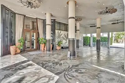 a large lobby with columns and a large room with plants at Brand New Mondrian - Miami Beach Waterfront Condo in Miami Beach