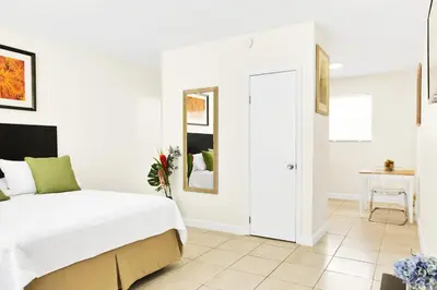 a white bedroom with a bed and a table at Mimo 10 - Kitchen - Walkable - Fast WiFi - Free Parking in Miami
