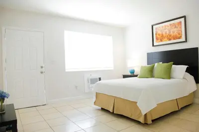 a white bedroom with a large bed with green pillows at New Mimo 8 New -Walkable - Smart TV - Nespresso - Free Parking in Miami
