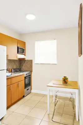 a kitchen with a white table and a white refrigerator at New Mimo 8 New -Walkable - Smart TV - Nespresso - Free Parking in Miami