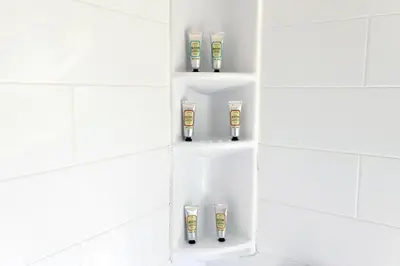 a shelf in a bathroom with four bottles of shampoo at South Beach South of Fifth 1 Bedroom Apartment Steps to Beach Sleeps 5 Pet Friendly in Miami Beach