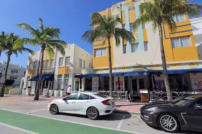 a white car parked on a street with palm trees at South Beach South of Fifth 1 Bedroom Apartment Steps to Beach Sleeps 5 Pet Friendly in Miami Beach