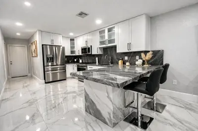 a large kitchen with a marble counter top at Villa Miami Lakes in Hialeah