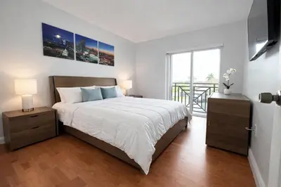 a bedroom with a large bed and a balcony at Villa Miami Lakes in Hialeah