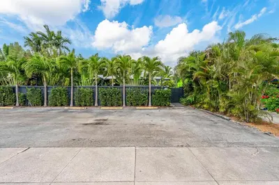 a parking lot with palm trees and a fence at New Apt 2 Bed 2 Bath with Amazing PATIO in Fort Lauderdale